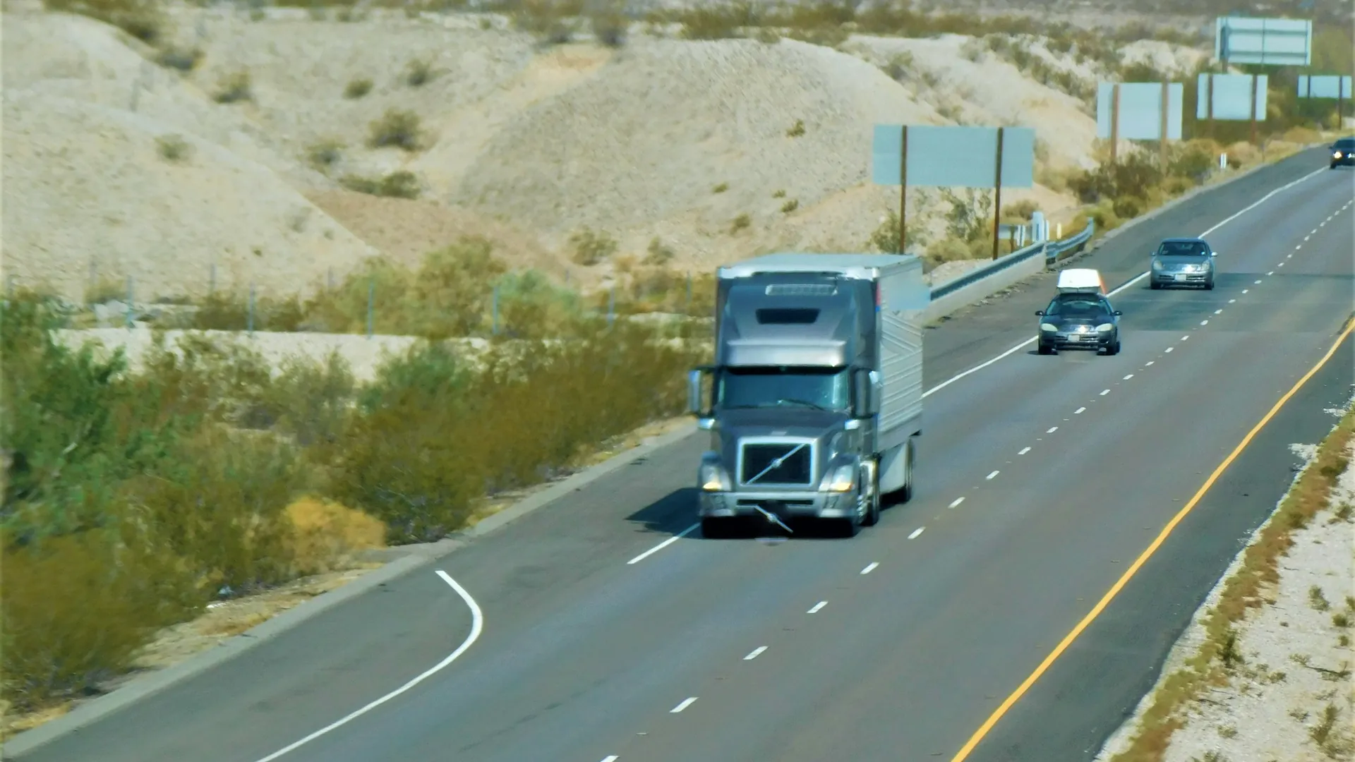 A tractor-trailer running a desert highway in the Southwest