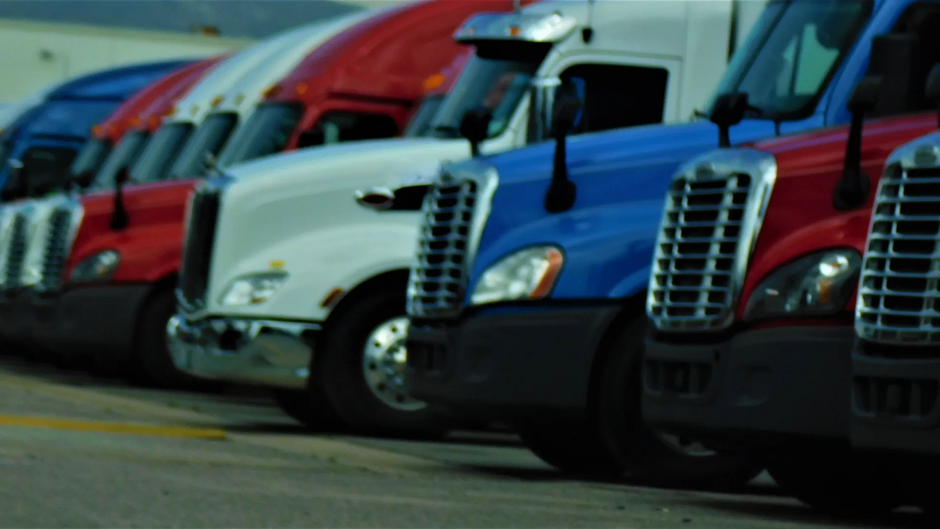A row of tractors lined up at a yard